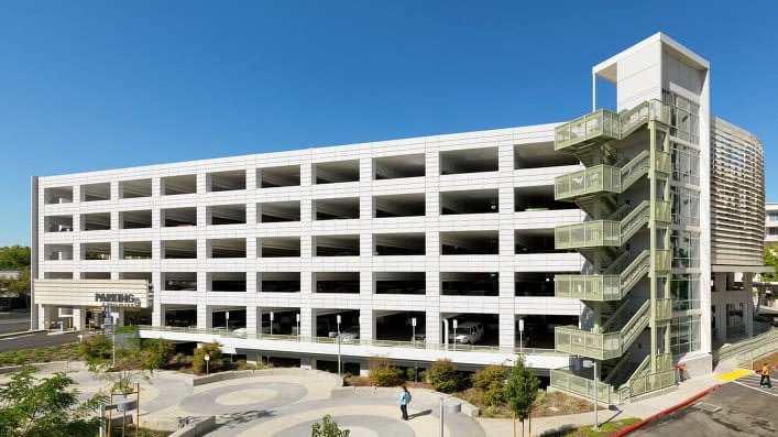 Large multi-level parking garage with exterior stairs.
