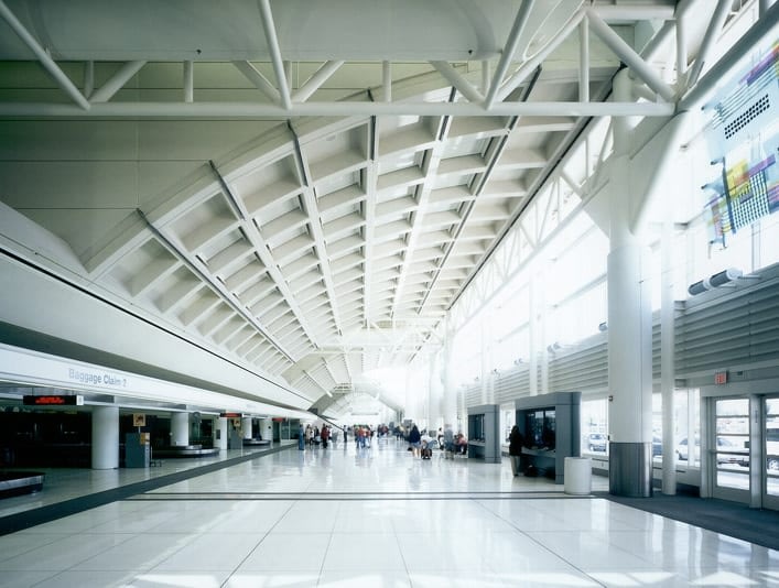 Spacious airport terminal with high ceilings and windows.