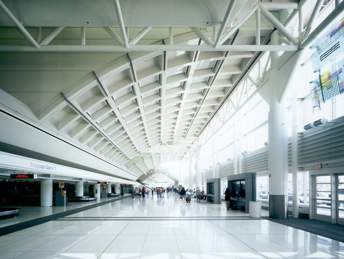 Spacious modern airport terminal with high ceiling.