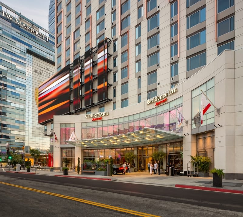Modern hotel exterior with flags and glass entrance.